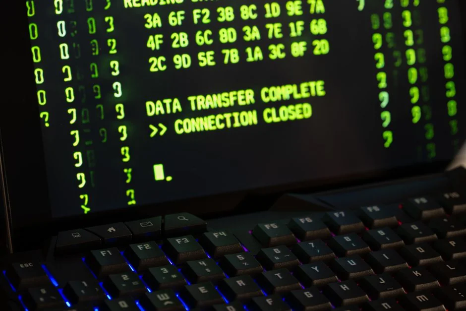 An adult is using a credit card to shop online on a laptop indoors.